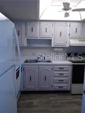a kitchen with granite countertop white cabinets and wooden floor