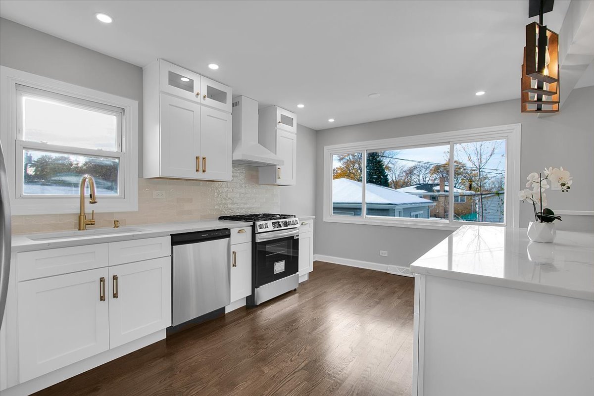 11524 South Kildare Avenue Alsip, IL 60803 - Photo 13 of 34 a large kitchen with stainless steel appliances a large counter top a stove a sink and a large window
