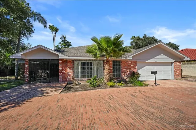 a front view of a house with a yard and potted plants