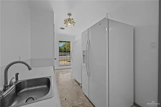 a kitchen with white cabinets and white appliances