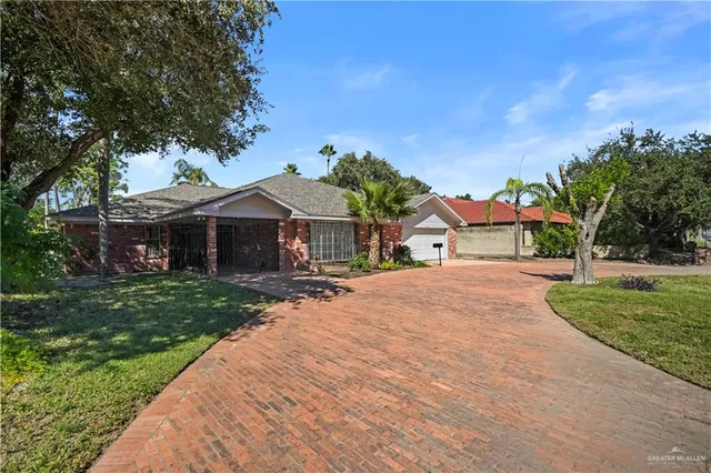 a front view of a house with a yard and green space