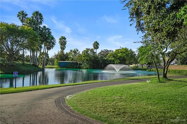 a view of a swimming pool with a lawn chairs under an umbrella