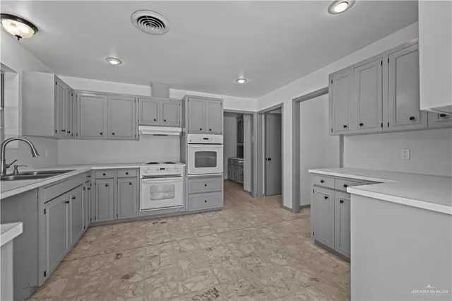 a kitchen with a sink stove and cabinets