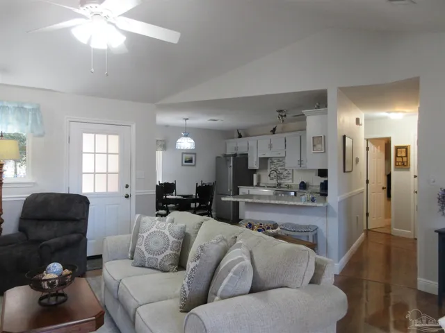 a kitchen with stainless steel appliances kitchen island granite countertop a dining table and chairs in it