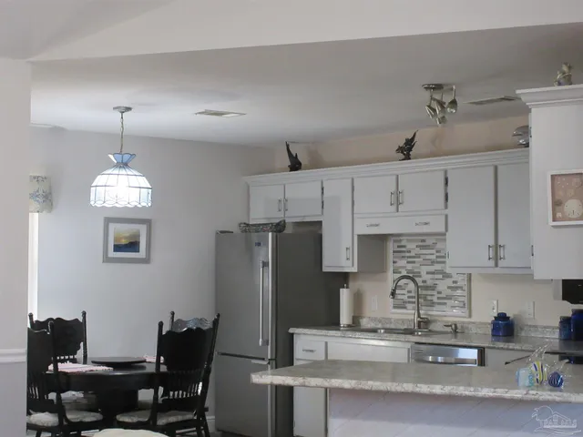 a kitchen with stainless steel appliances granite countertop a sink a stove and a granite counter tops