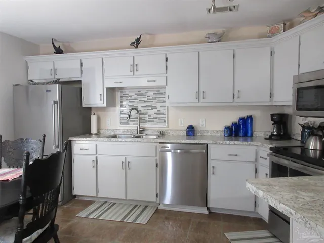 a kitchen with stainless steel appliances granite countertop a stove and a sink