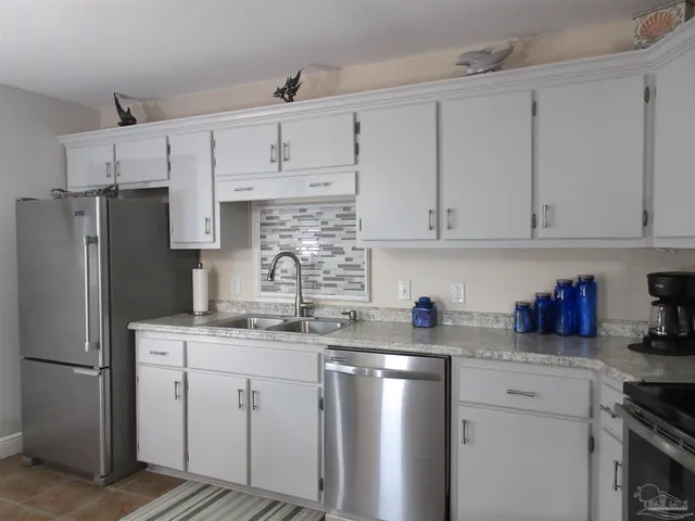 a kitchen with granite countertop a sink a stove and cabinets