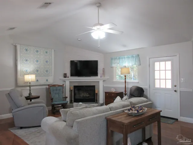 a living room with furniture a flat screen tv and a fireplace