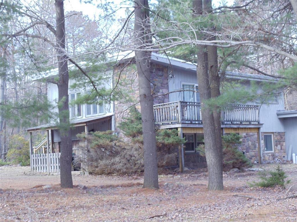 a view of a house with a yard and hanging chair