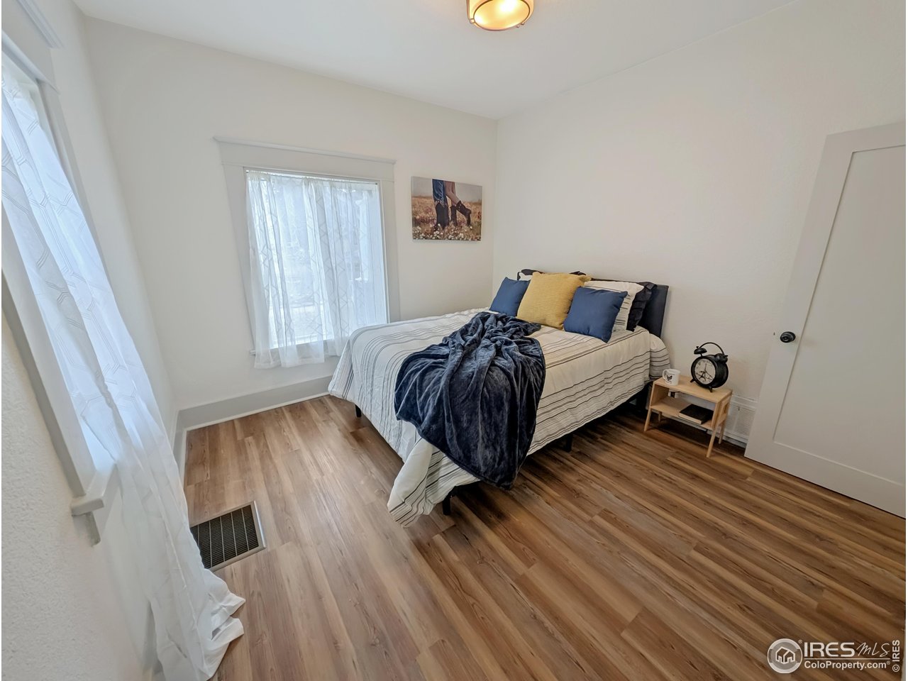 710 Carson Street Brush, CO 80723 - Photo 12 of 31 a bedroom with a bed and wooden floor