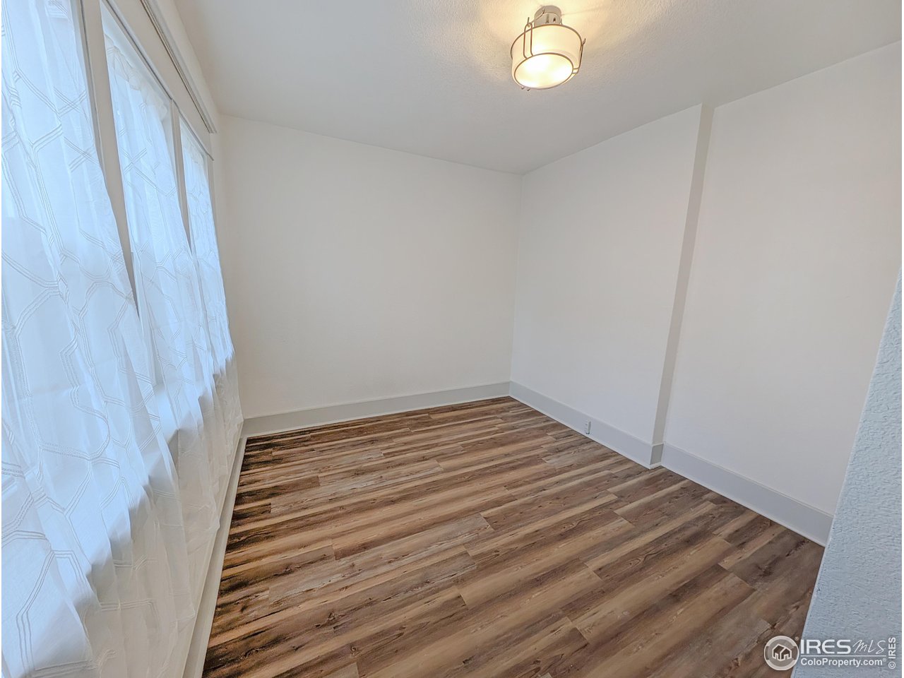 710 Carson Street Brush, CO 80723 - Photo 16 of 31 a view of a room with wooden floor and white walls