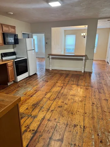 a view of a kitchen with microwave and white cabinets
