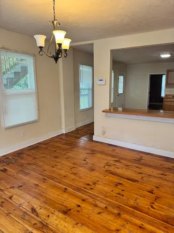 a view of a livingroom with a chandelier fan and wooden floor