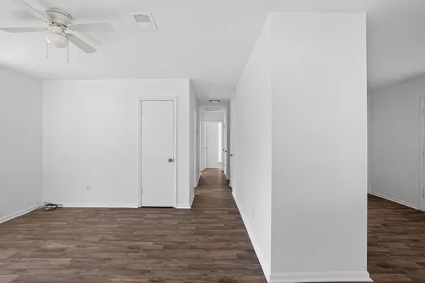 a view of a hallway with wooden floor and closet