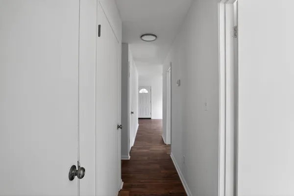 a view of a hallway with wooden floor