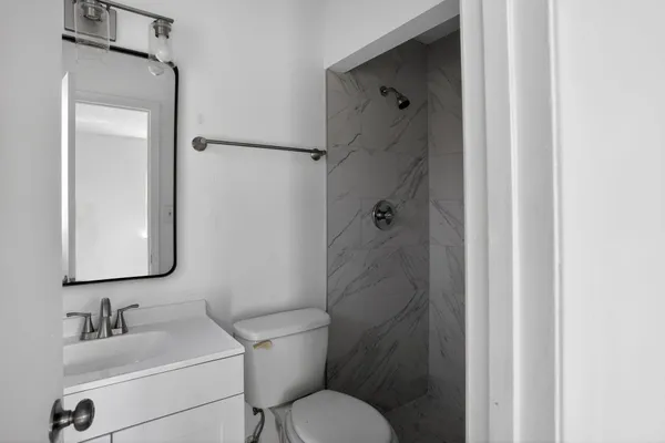 a bathroom with a toilet sink shower and mirror