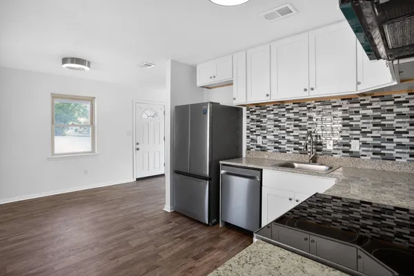 a kitchen with granite countertop a stove and a refrigerator
