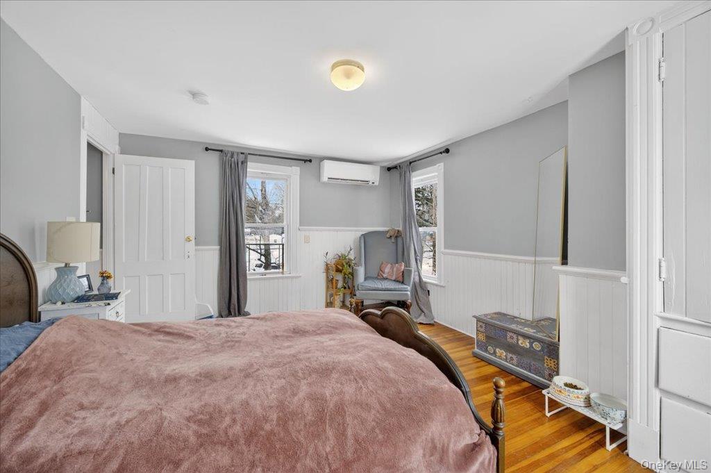 792 Springtown Road Rosendale, NY 12486 - Photo 18 of 45 Bedroom with wainscoting, wood finished floors, and a wall mounted AC