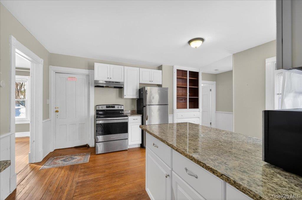 792 Springtown Road Rosendale, NY 12486 - Photo 30 of 45 Kitchen with electric range, white cabinetry, light stone counters, dark wood-style flooring, and under cabinet range hood