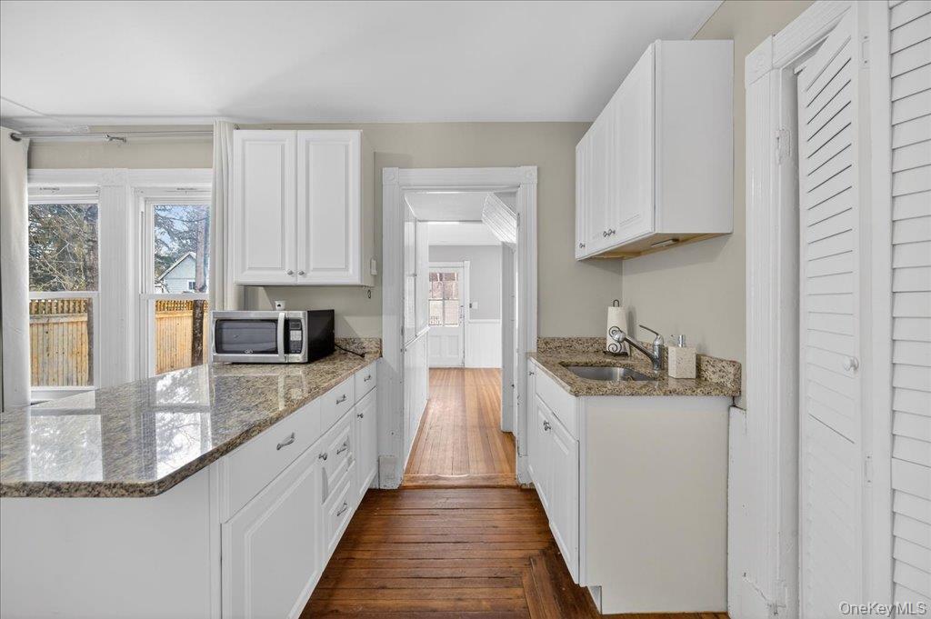 792 Springtown Road Rosendale, NY 12486 - Photo 33 of 45 Kitchen with light stone counters, white cabinets, stainless steel microwave, and a peninsula
