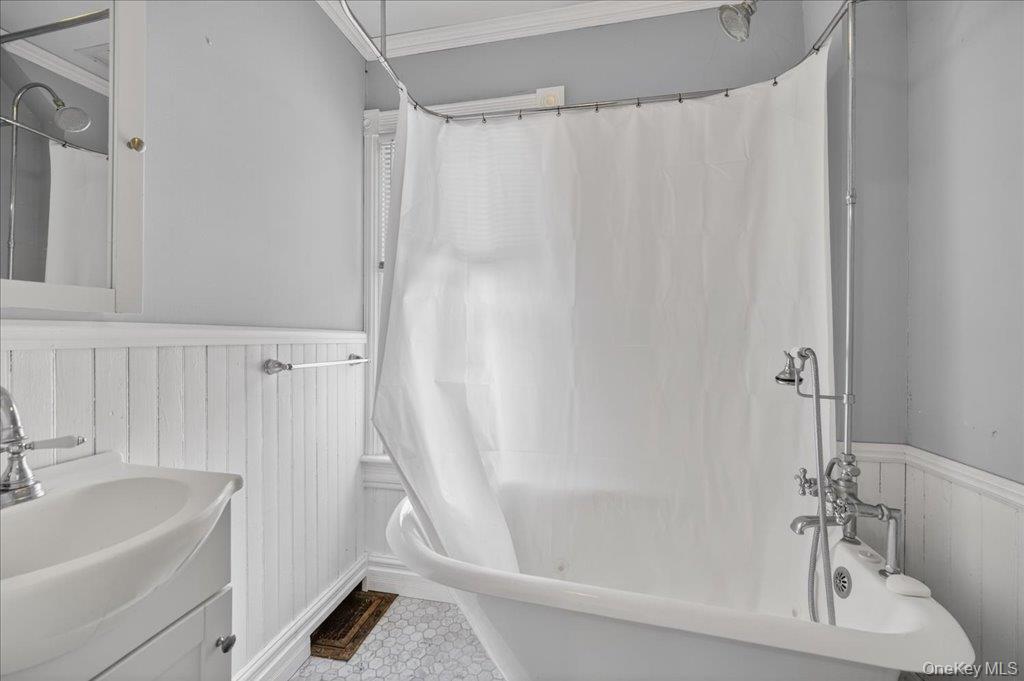792 Springtown Road Rosendale, NY 12486 - Photo 35 of 45 Full bathroom featuring wainscoting, ornamental molding, vanity, a decorative wall, and wood walls