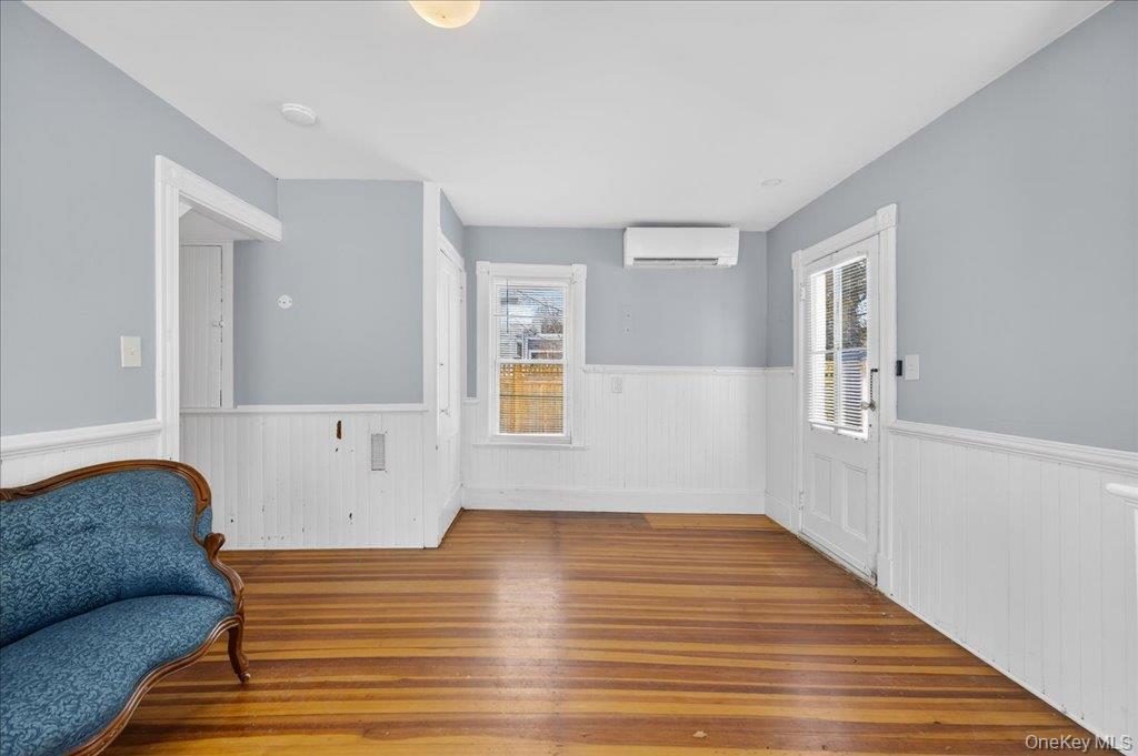 792 Springtown Road Rosendale, NY 12486 - Photo 40 of 45 Living area featuring light wood-style flooring, wainscoting, and an AC wall unit
