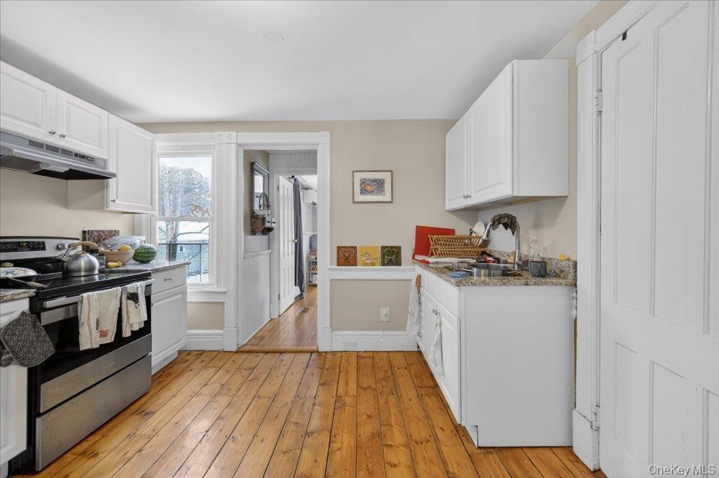 792 Springtown Road Rosendale, NY 12486 - Photo 8 of 45 Kitchen featuring stainless steel electric range, white cabinets, under cabinet range hood, light wood-style floors, and light stone countertops