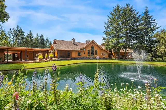 a view of house with swimming pool next to trees