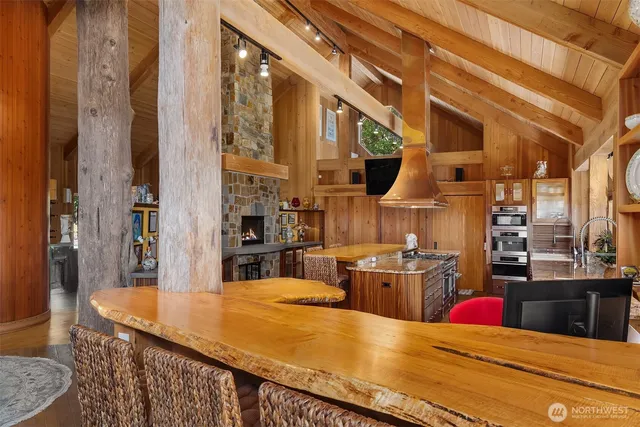 a kitchen with stainless steel appliances kitchen island granite countertop a table chairs in it and wooden floors