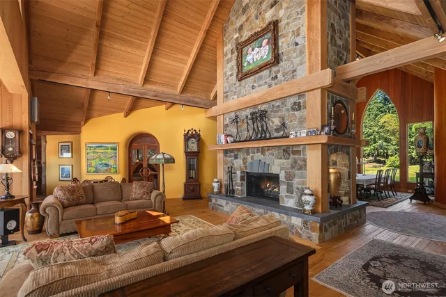 a living room with furniture a fireplace and a floor to ceiling window