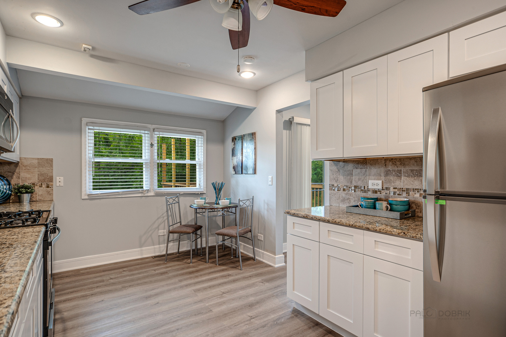 110 Haman Road Inverness, IL 60010 - Photo 8 of 30 a kitchen with stainless steel appliances a refrigerator a stove a dining table and chairs with wooden floor