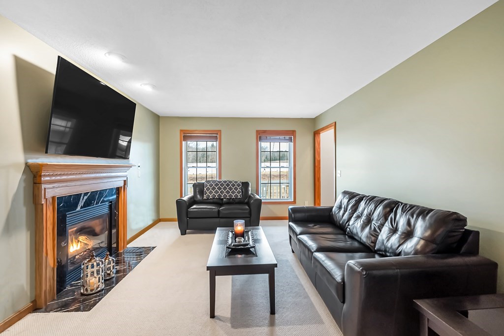 34 Schneider Road Somers, CT 06071 - Photo 4 of 42 a living room with furniture a flat screen tv and a fireplace