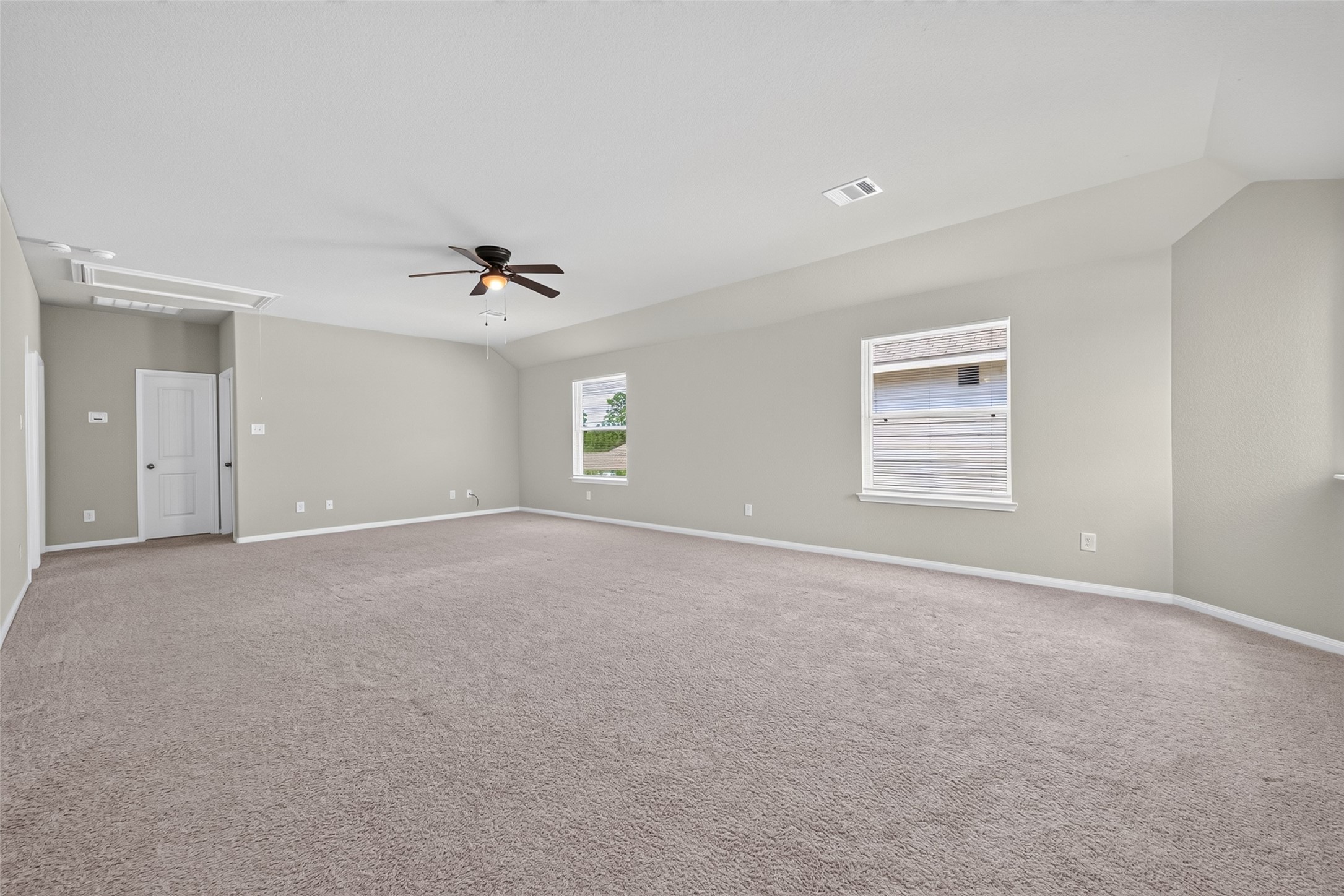 2526 Sturgeon Way Conroe, TX 77384 - Photo 27 of 49 This spacious, carpeted room features neutral walls, two large windows for natural light, a ceiling fan, and a door leading to another area, ideal for customization.