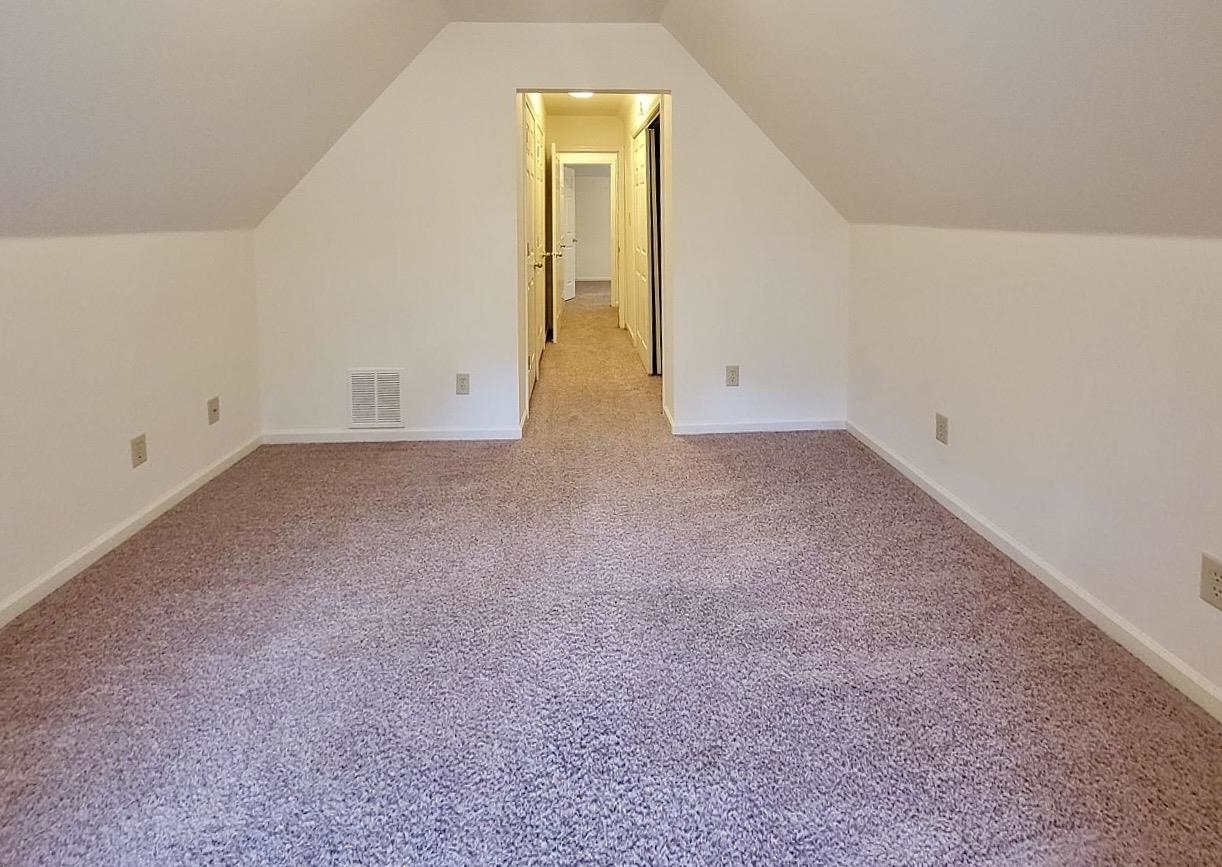 8326 Twin Rivers Drive Memphis, TN 38016 - Photo 12 of 21 Carpeted room with angled ceilings and a central hallway