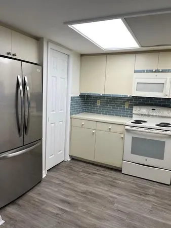 a kitchen with granite countertop a refrigerator stove and microwave