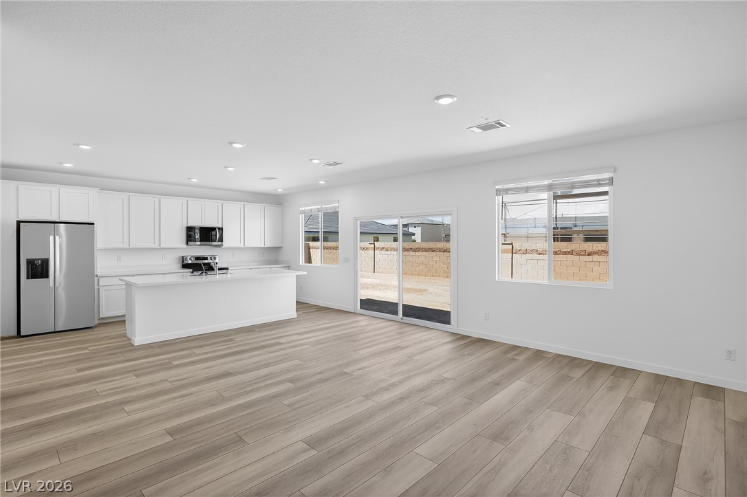 347 Sam Way Mesquite, NV 89027 - Photo 12 of 32 A contemporary open-plan kitchen and living space, featuring wood flooring and ample natural light.
