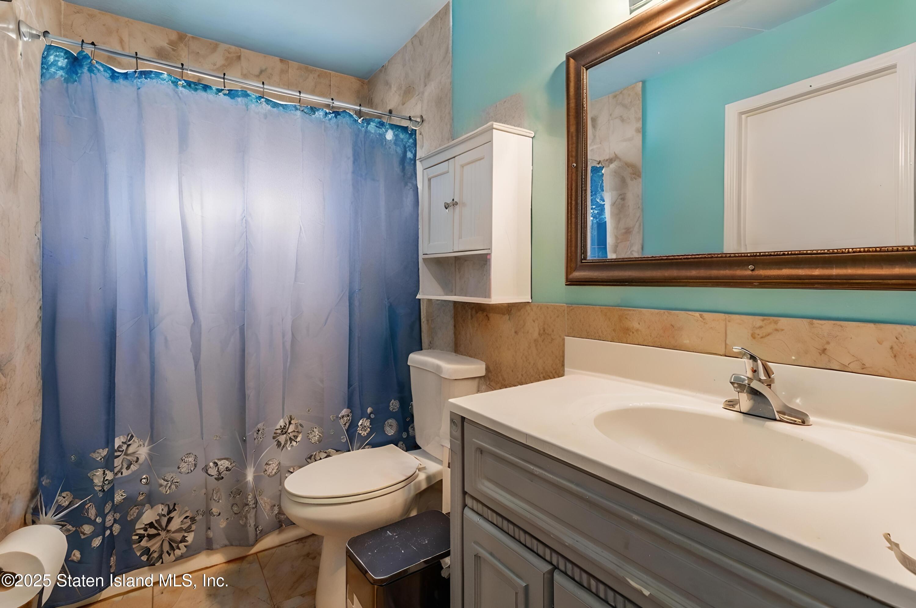 27 Bascom Place Staten Island, NY 10314 - Photo 12 of 25 a bathroom with a sink a toilet and mirror