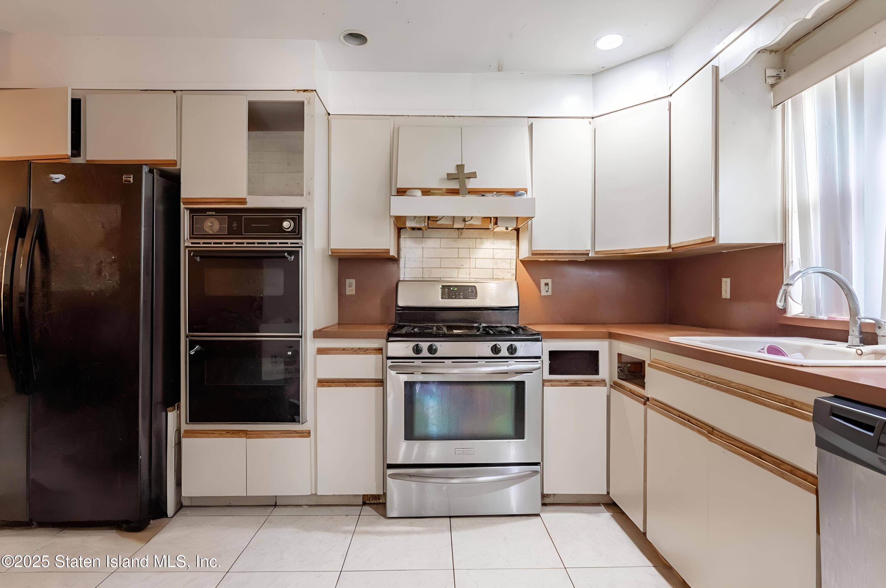 27 Bascom Place Staten Island, NY 10314 - Photo 13 of 25 a kitchen with stainless steel appliances granite countertop a stove a refrigerator and a sink