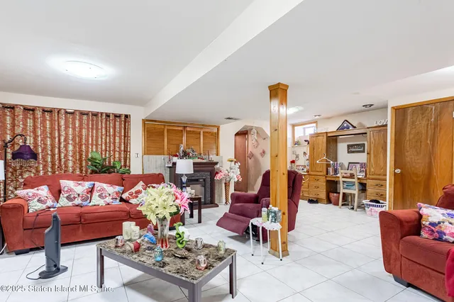 a living room with furniture a flat screen tv and a window