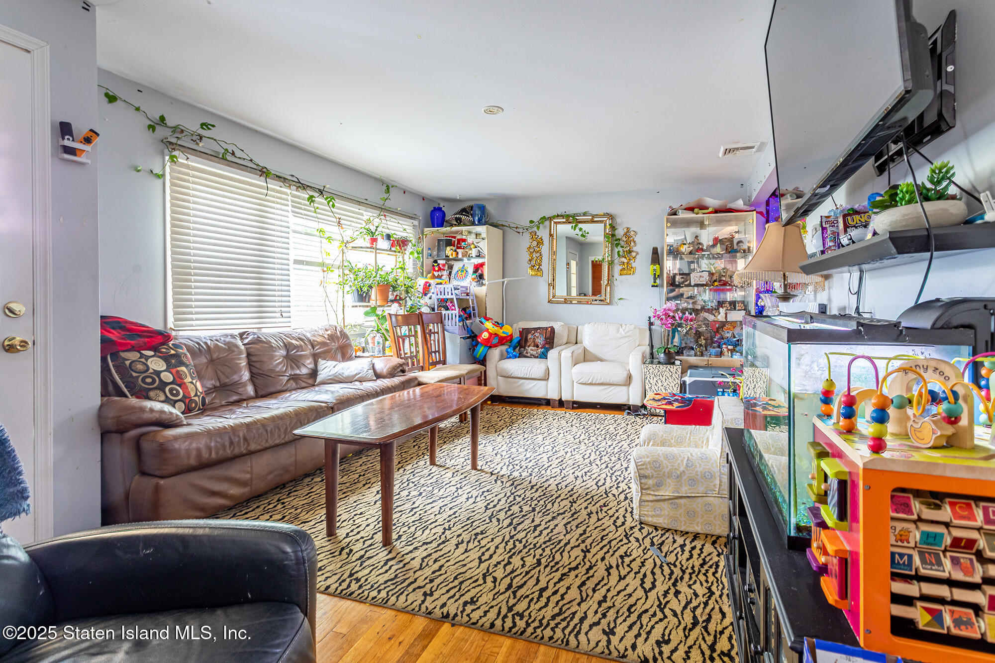 27 Bascom Place Staten Island, NY 10314 - Photo 6 of 25 a living room with furniture cabinets and a window