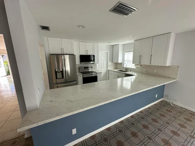 a view of a kitchen with microwave and cabinets