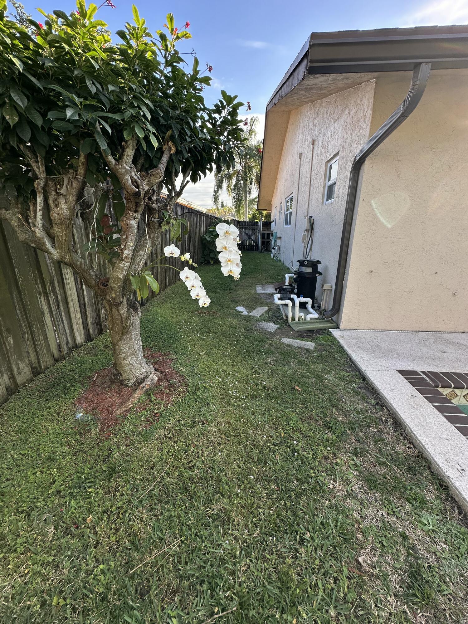 3291 Southwest 4th Street Deerfield Beach, FL 33442 - Photo 35 of 38 a backyard of a house with table and chairs