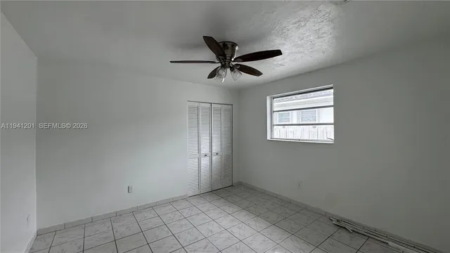 a view of a livingroom with a ceiling fan and window