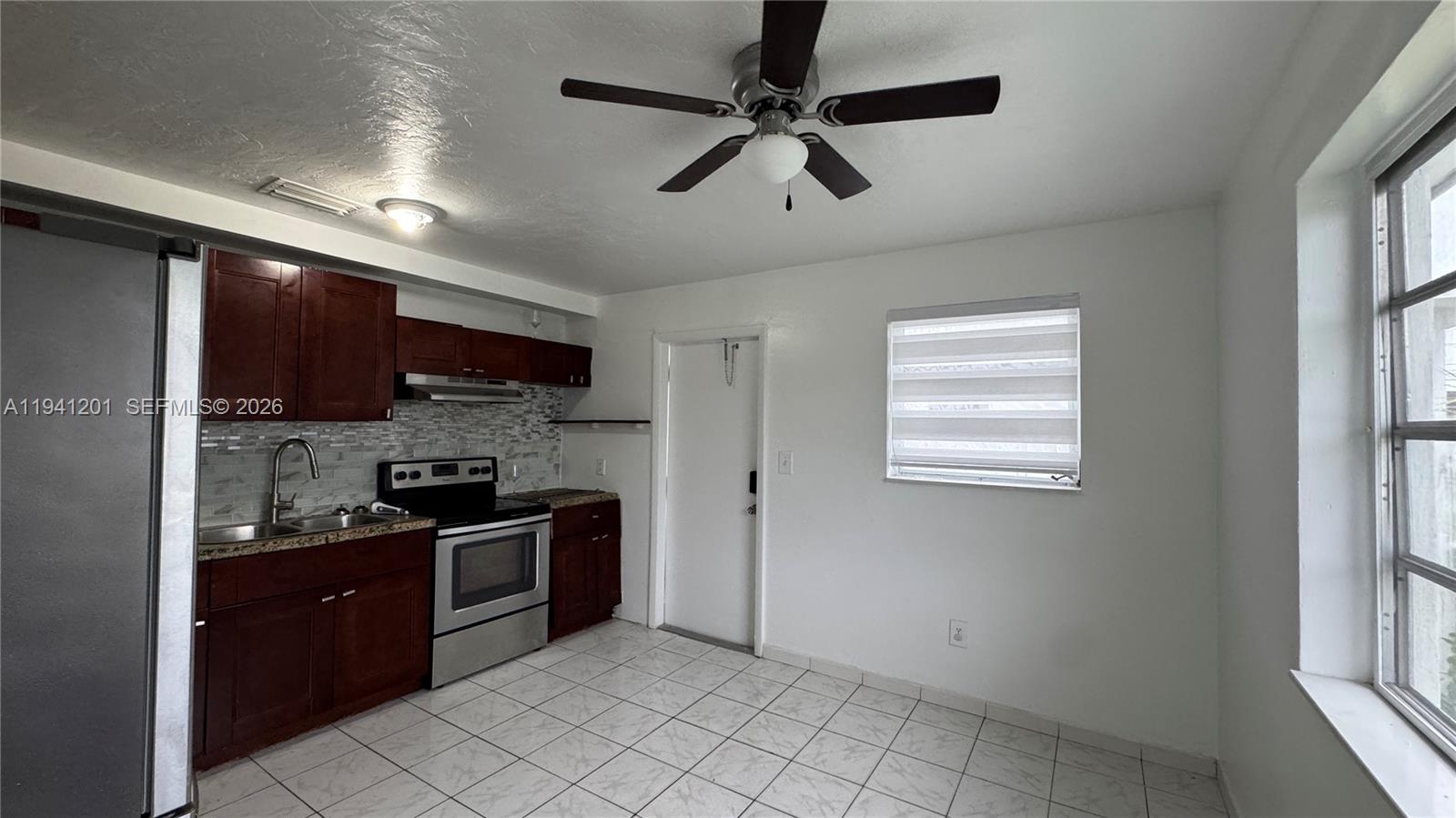 7235 Southwest 23rd Street, Unit 7235 Miami, FL 33155 - Photo 6 of 15 a kitchen with stainless steel appliances granite countertop a stove a sink and a refrigerator