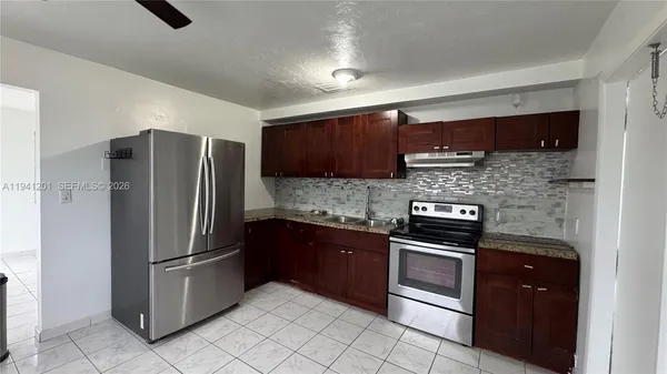 a kitchen with stainless steel appliances granite countertop a refrigerator and a stove top oven