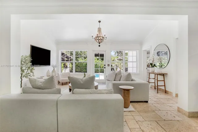 a living room with furniture a flat screen tv and a large window