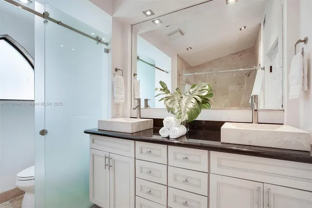 a bedroom with a large bed and a chandelier fan