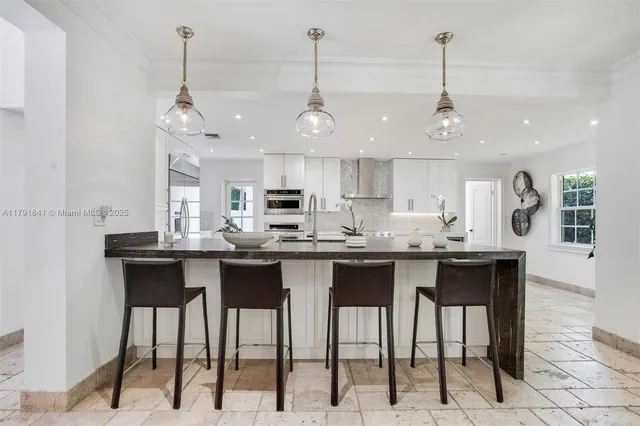 a kitchen with stainless steel appliances kitchen island granite countertop a refrigerator and a sink
