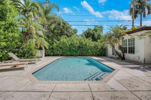 an aerial view of a house with a yard swimming pool outdoor seating and yard