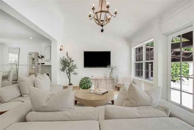 a living room with furniture a flat screen tv and a large window